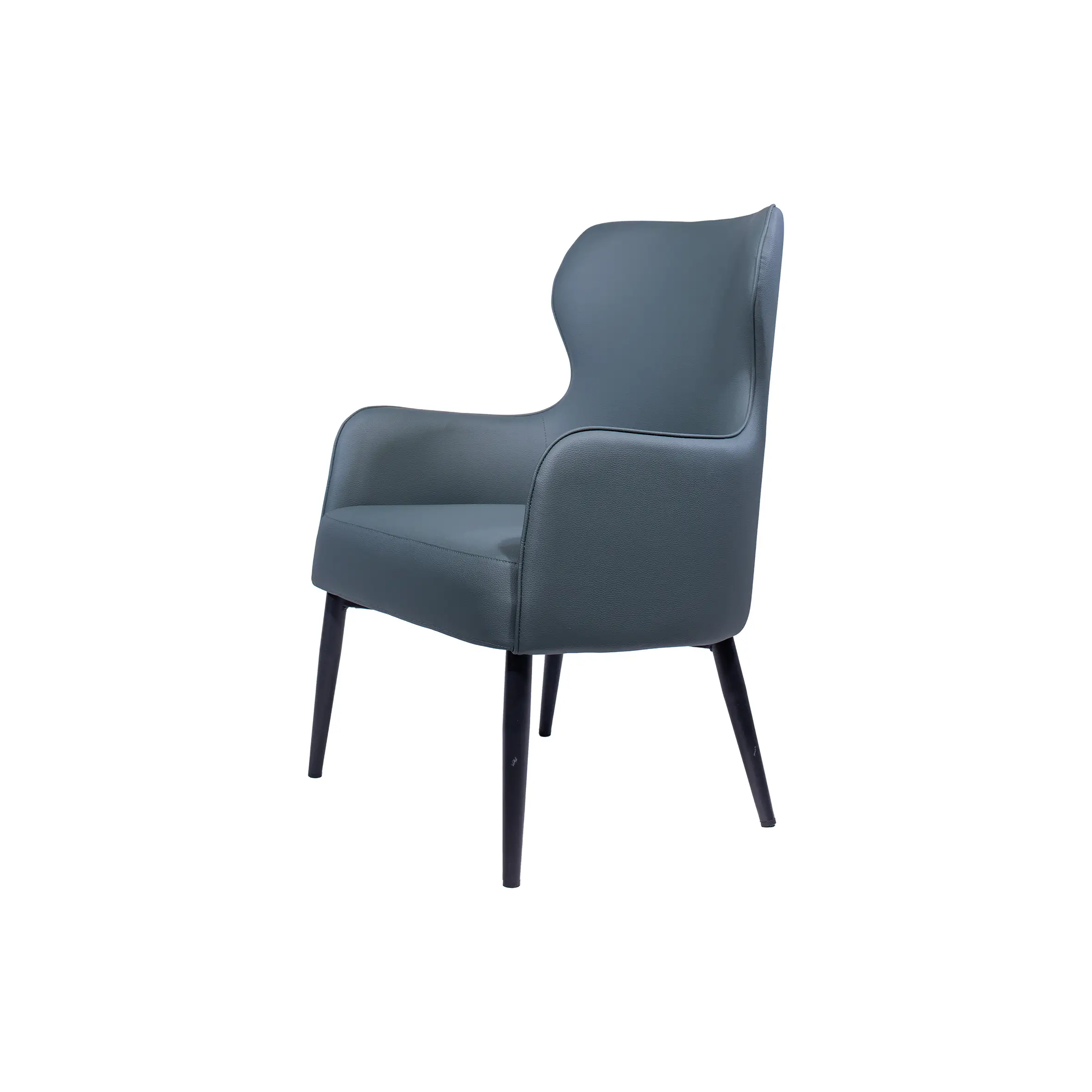 Modern office space with two dark gray armchairs facing a round black table. Background features white desks and office chairs near large windows.