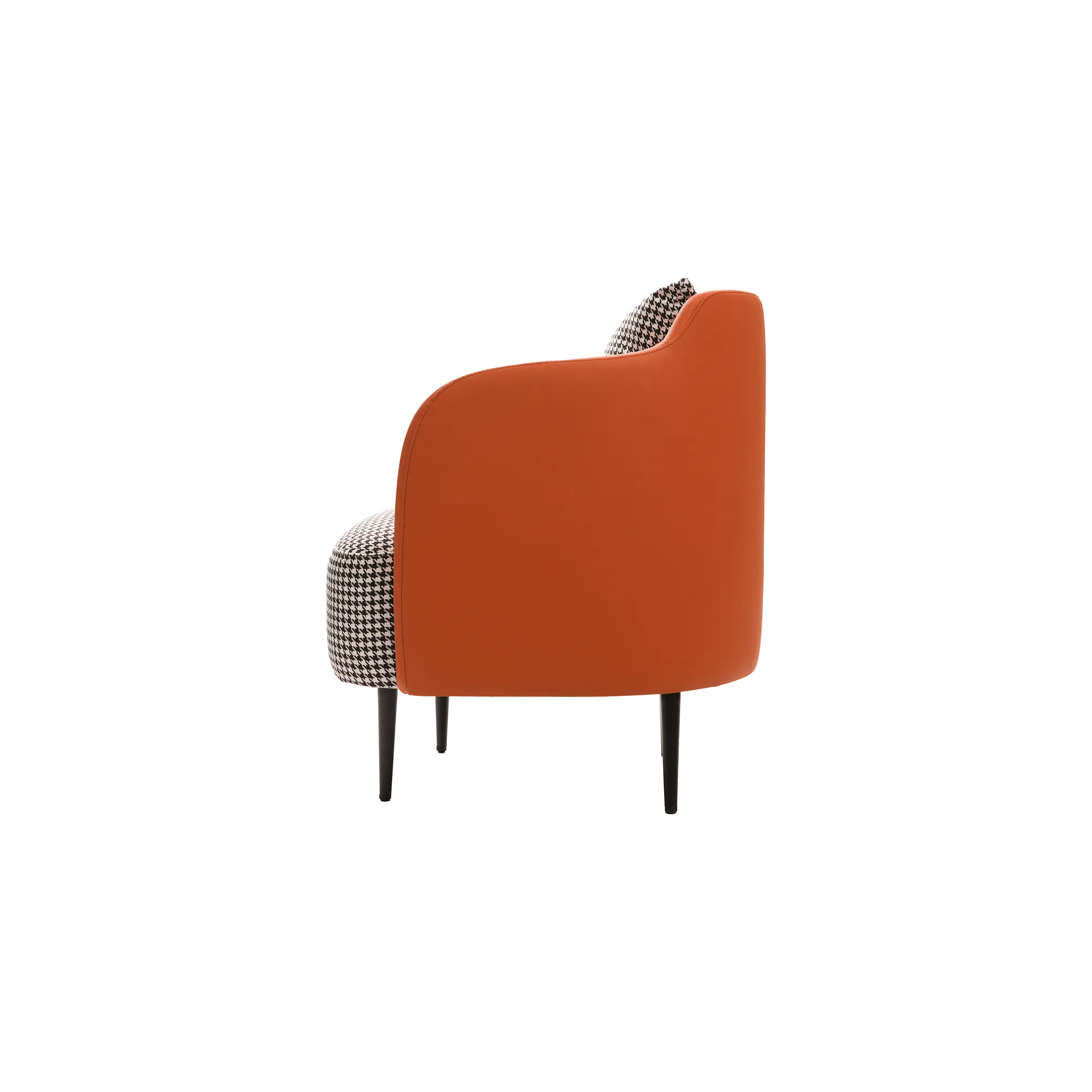 Minimalist office with a white desk, computer, black chair, and black binders. Orange and houndstooth armchair adds a pop of color, exuding modern elegance.