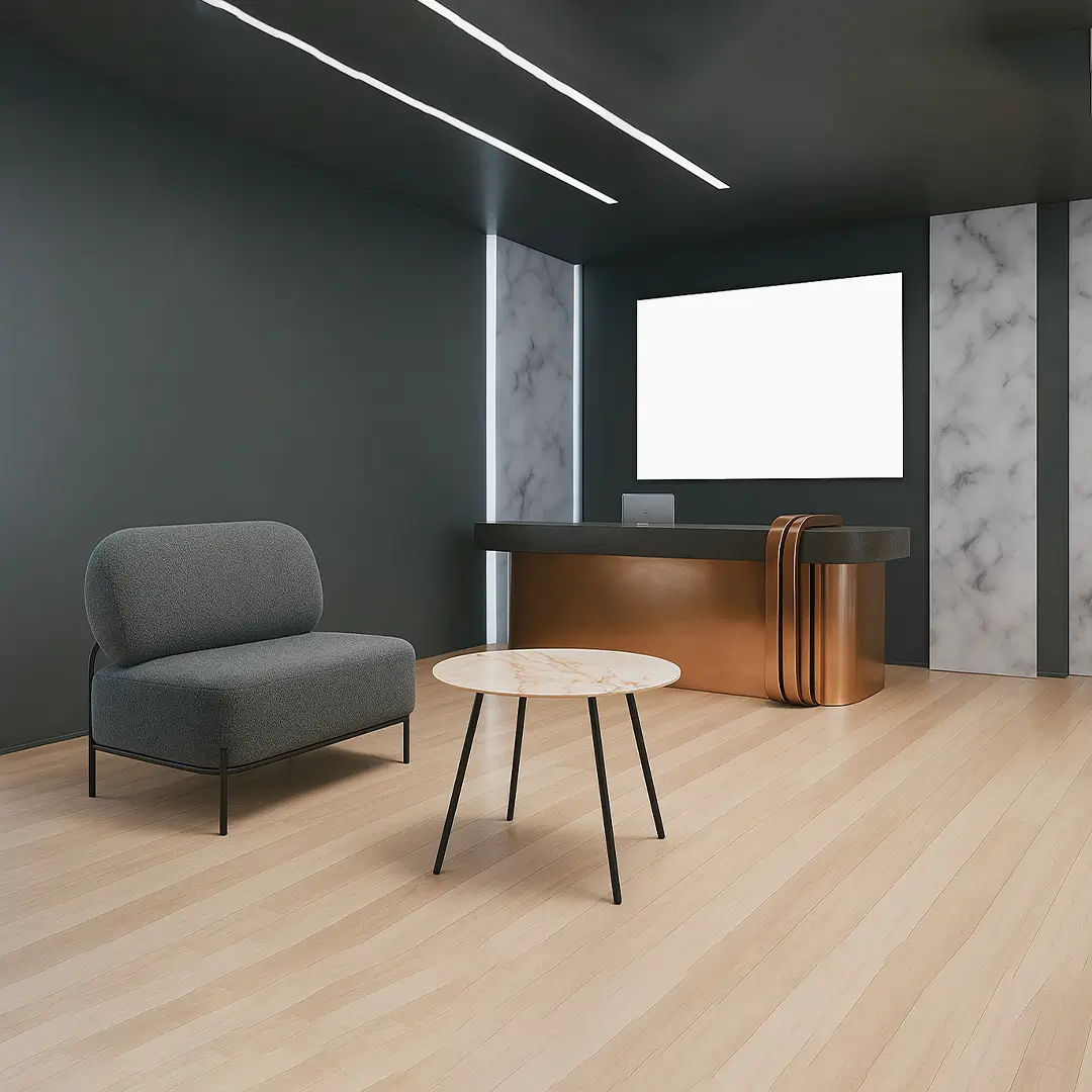 Modern office interior with dark walls and light wood floor. Features a sleek reception desk, gray couch, round marble-topped table, and minimal lighting.