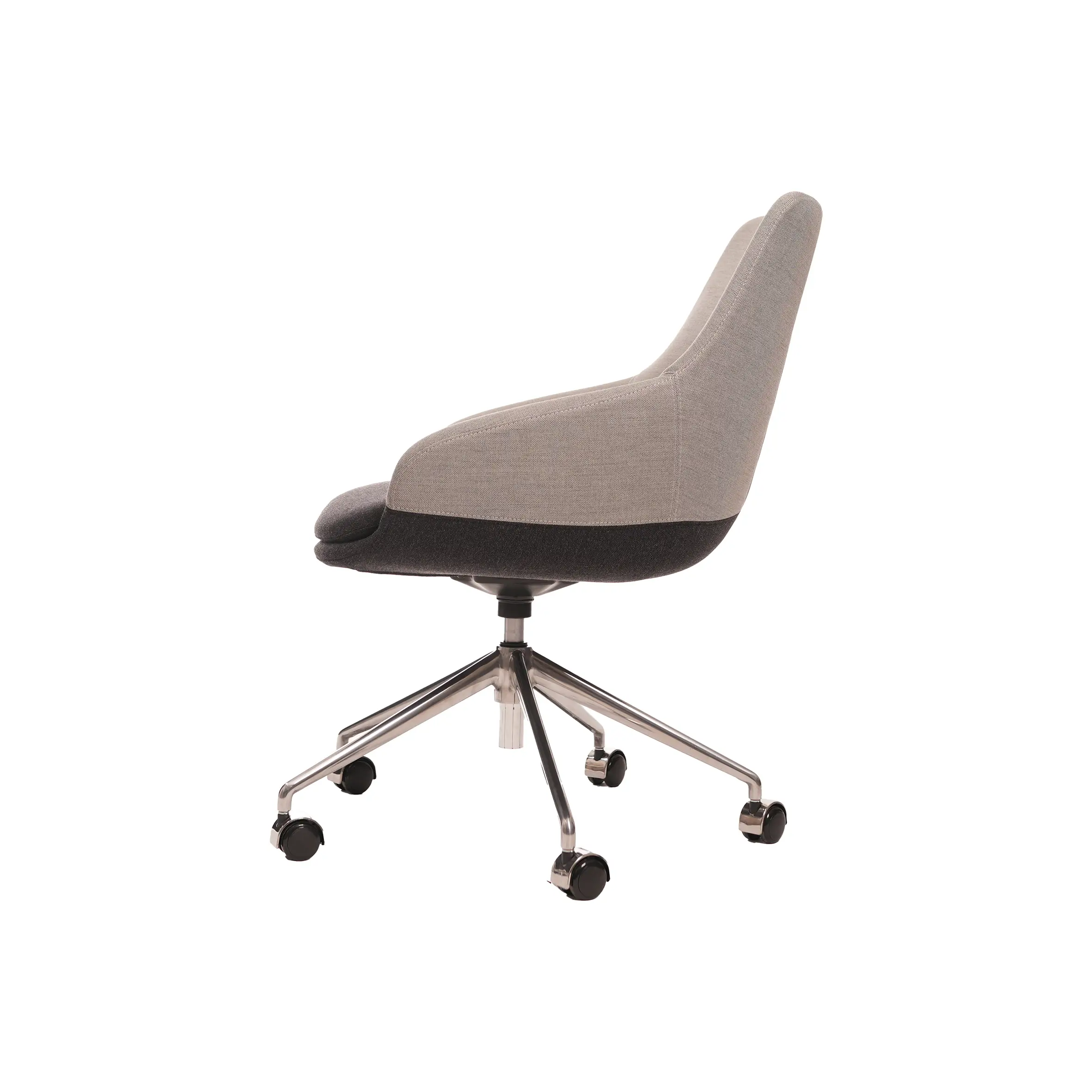 Modern office space with wooden L-shaped desk, gray swivel chair, and open laptop. A green plant adds a touch of nature. Large window view outside.