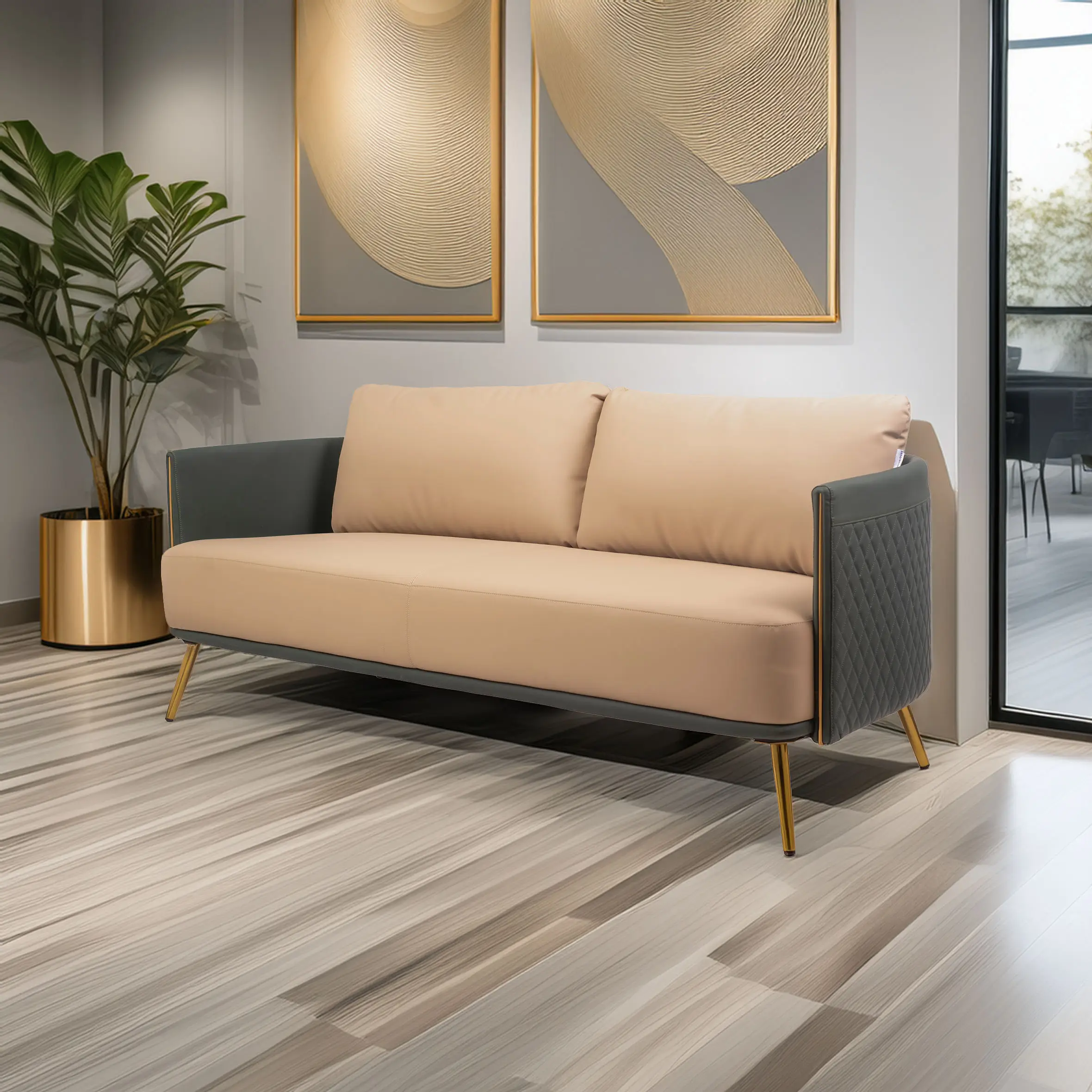 Modern beige sofa with dark armrests and gold legs in a stylish living room. Two abstract paintings and a potted plant add elegance and warmth.