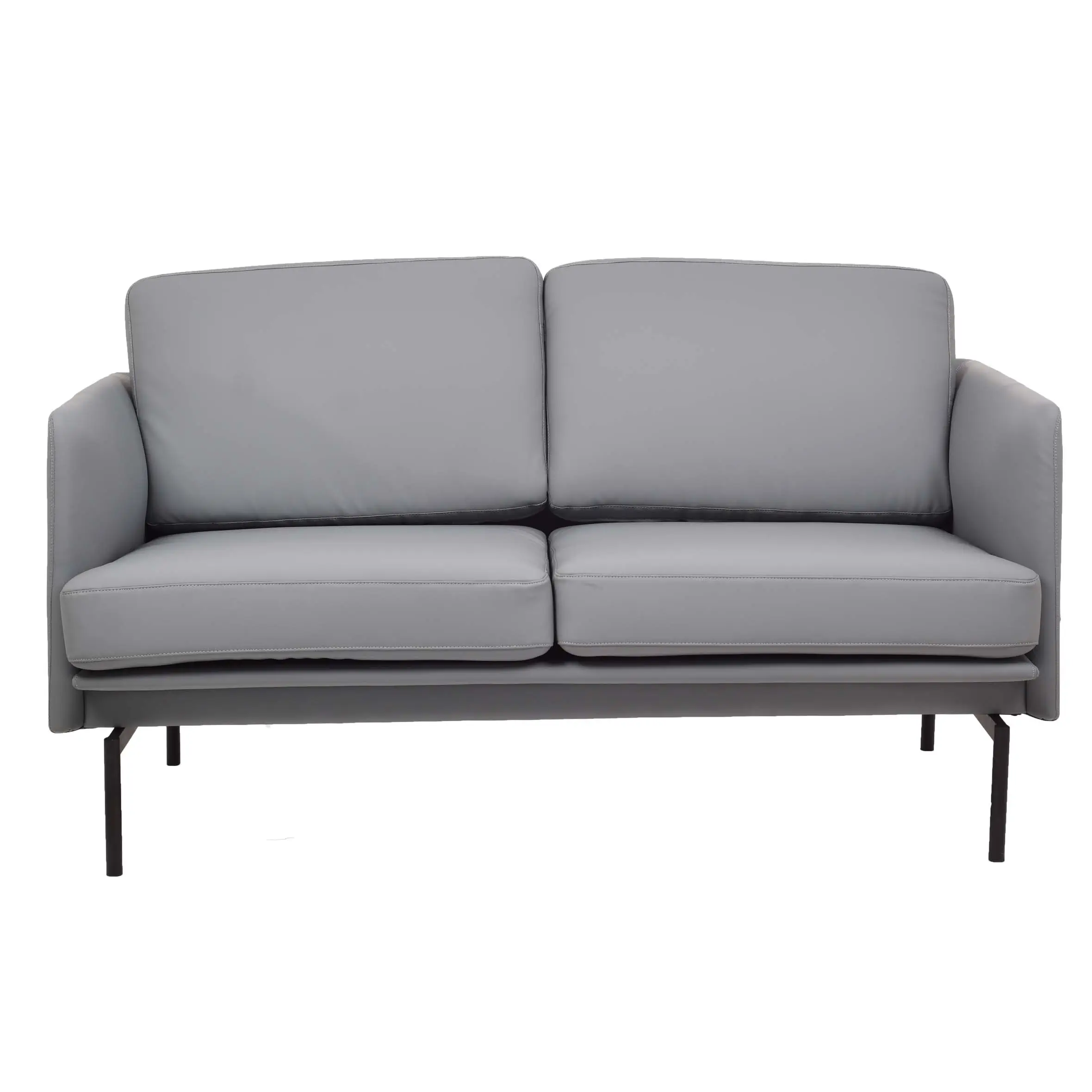 Modern office lounge with a grey sofa and ottoman on a textured rug. Large windows offer a city view, and potted plants add a fresh touch.