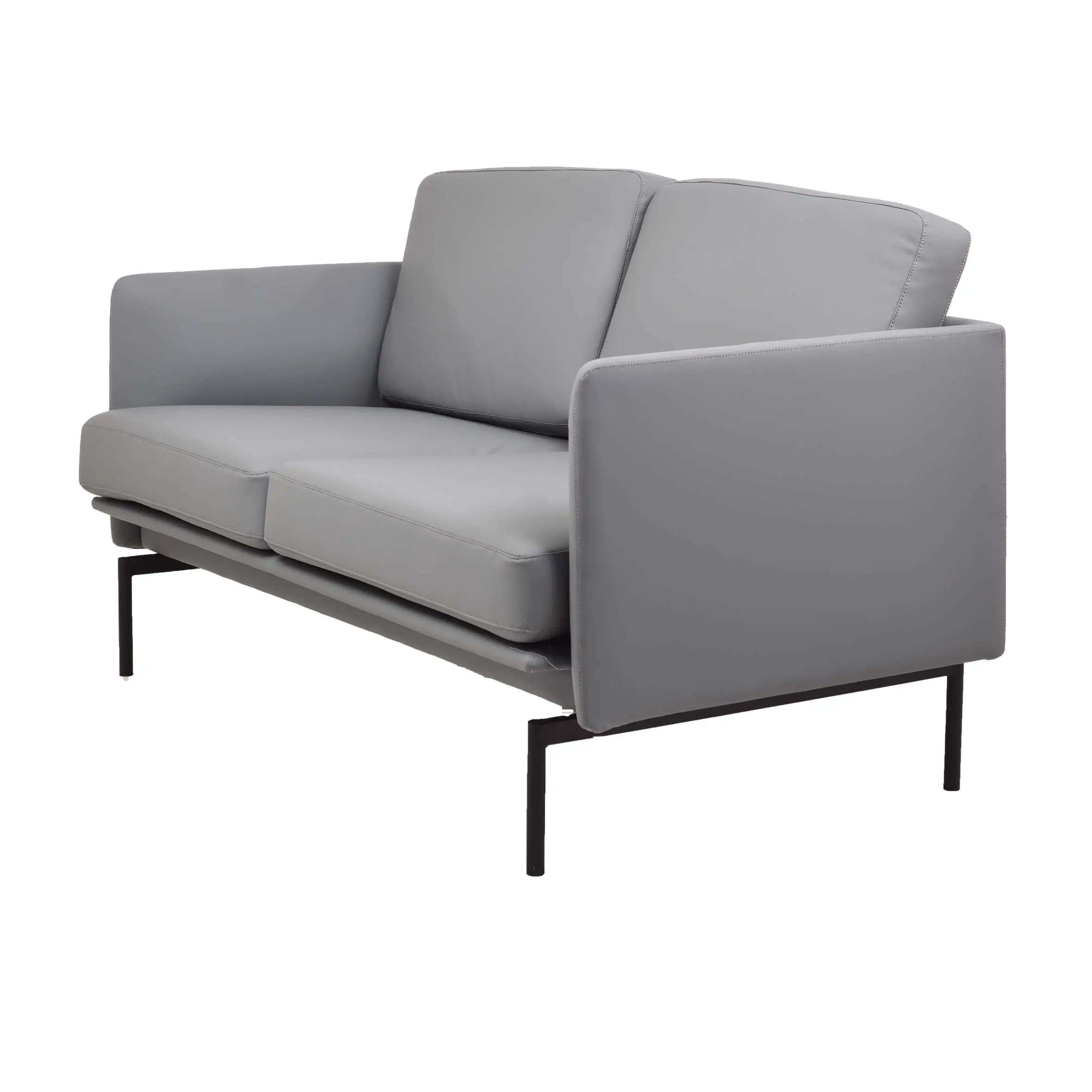 Modern office lounge with a grey sofa and ottoman on a textured rug. Large windows offer a city view, and potted plants add a fresh touch.