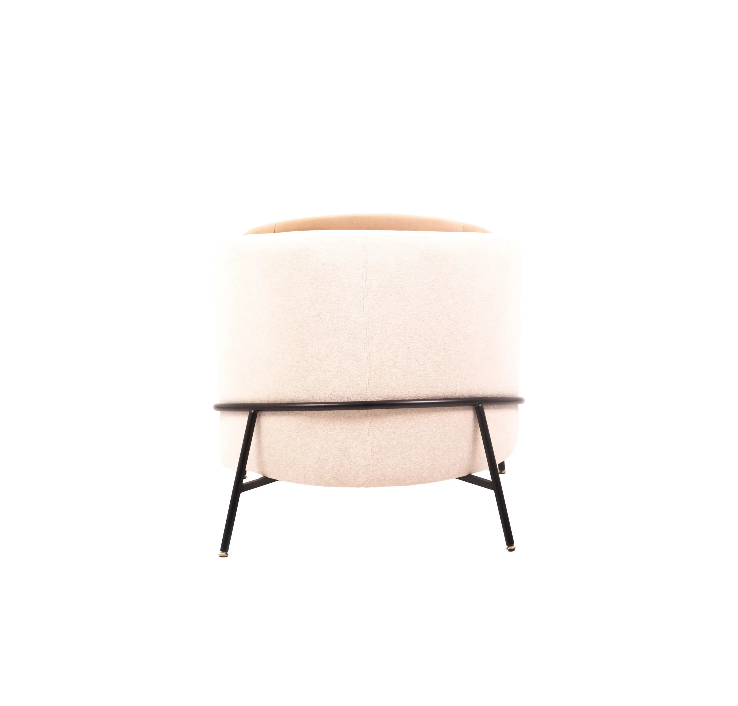 A modern beige armchair with black legs rests on a light gray rug. A round table with stacked magazines and a vase with dried flowers is beside it.