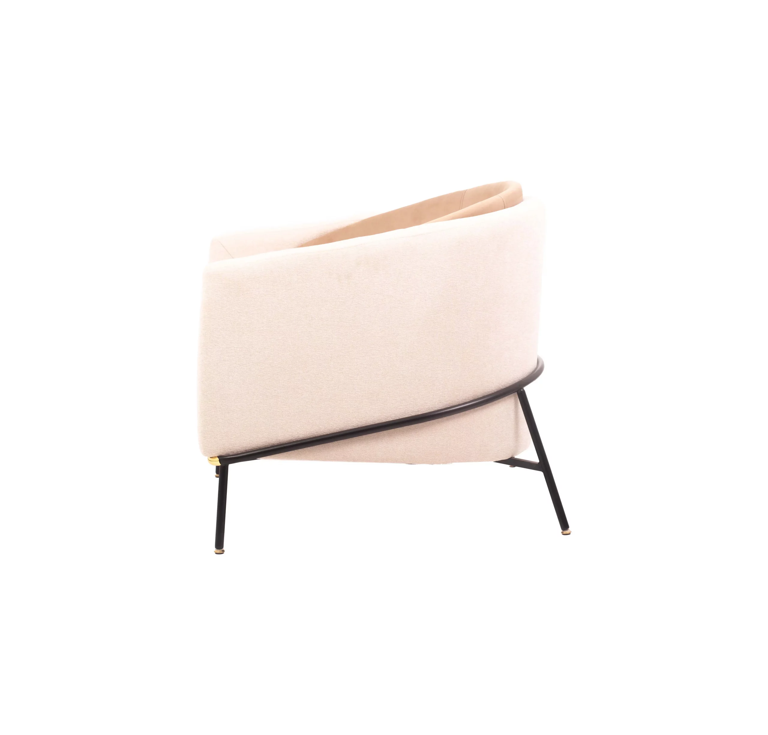 A modern beige armchair with black legs rests on a light gray rug. A round table with stacked magazines and a vase with dried flowers is beside it.