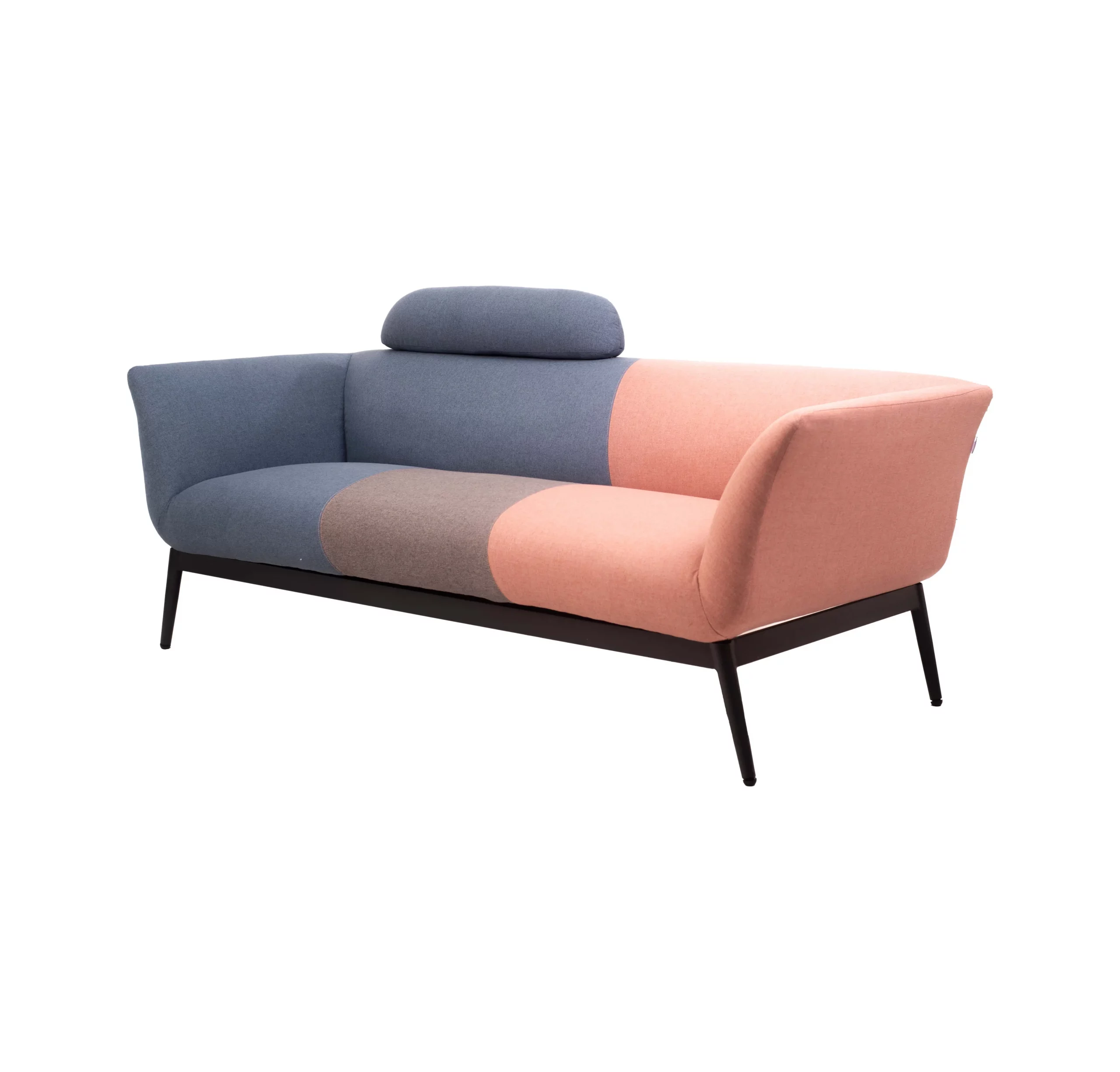 Colorful modern sofa with pink, brown and blue patchwork design. It's set against a minimalist backdrop, flanked by green plants and black pendant lights.