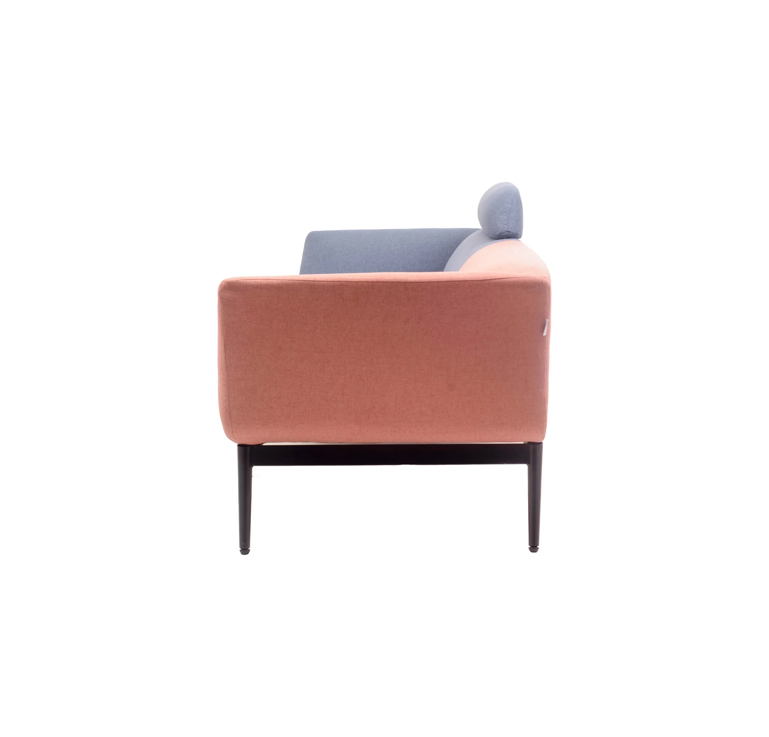 Colorful modern sofa with pink, brown and blue patchwork design. It's set against a minimalist backdrop, flanked by green plants and black pendant lights.