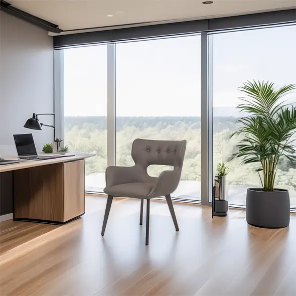 Modern office space with large windows, wooden floors, and a sleek grey chair. A desk with a lamp and laptop, plus a potted plant, conveys a calm, professional atmosphere.