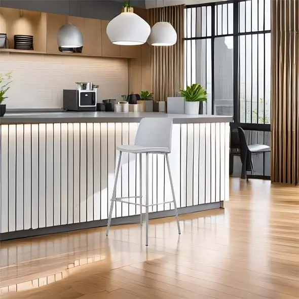 Modern kitchen with sleek white cabinets, wooden accents, and hanging pendant lights. A tall grey chair stands beside a striped island counter.