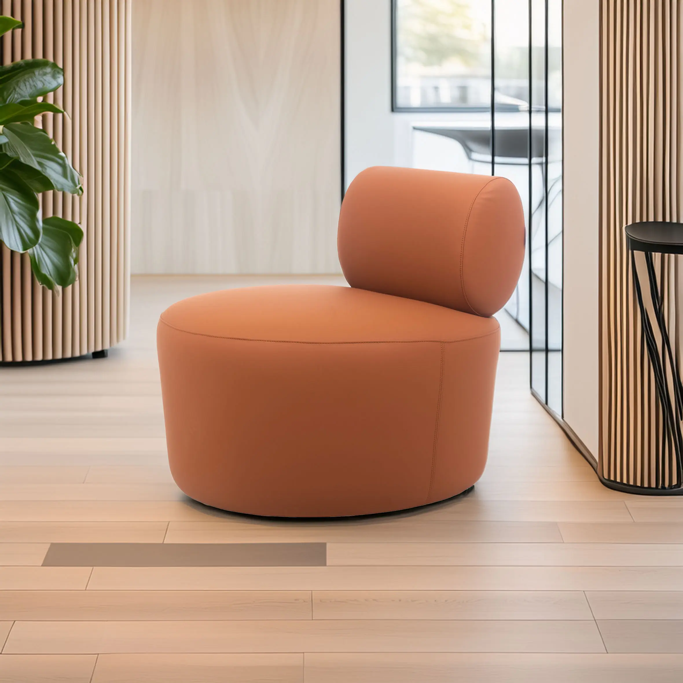 A modern, round, orange chair with a cylindrical backrest on light wood flooring. Background features a plant, striped walls, and a window, creating a sleek, serene ambiance.