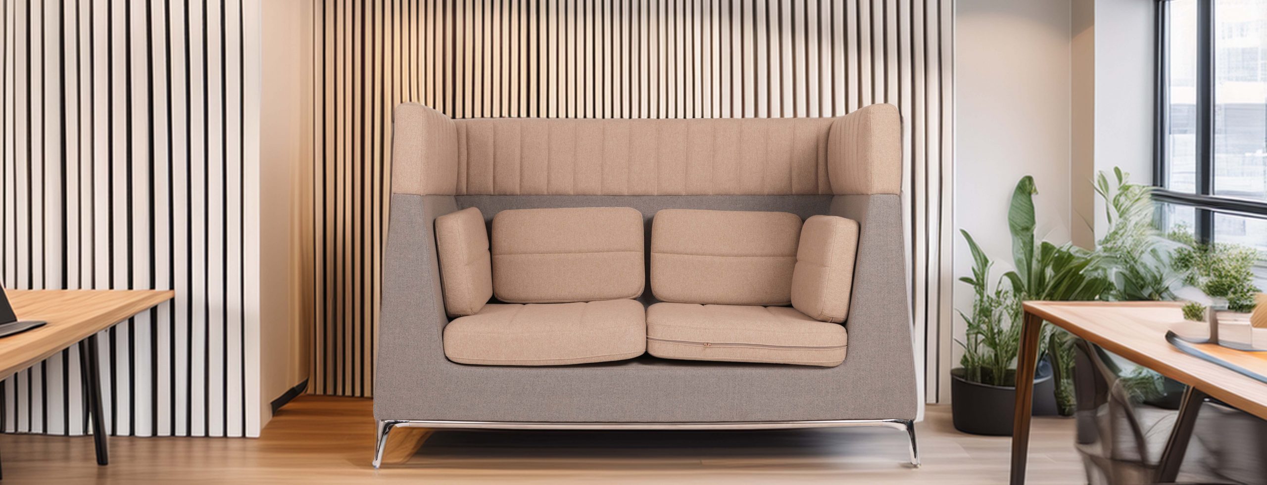Modern office pod with padded beige seating, surrounded by vertical striped panels. A wooden table with a laptop and plants nearby conveys a cozy, focused workspace.