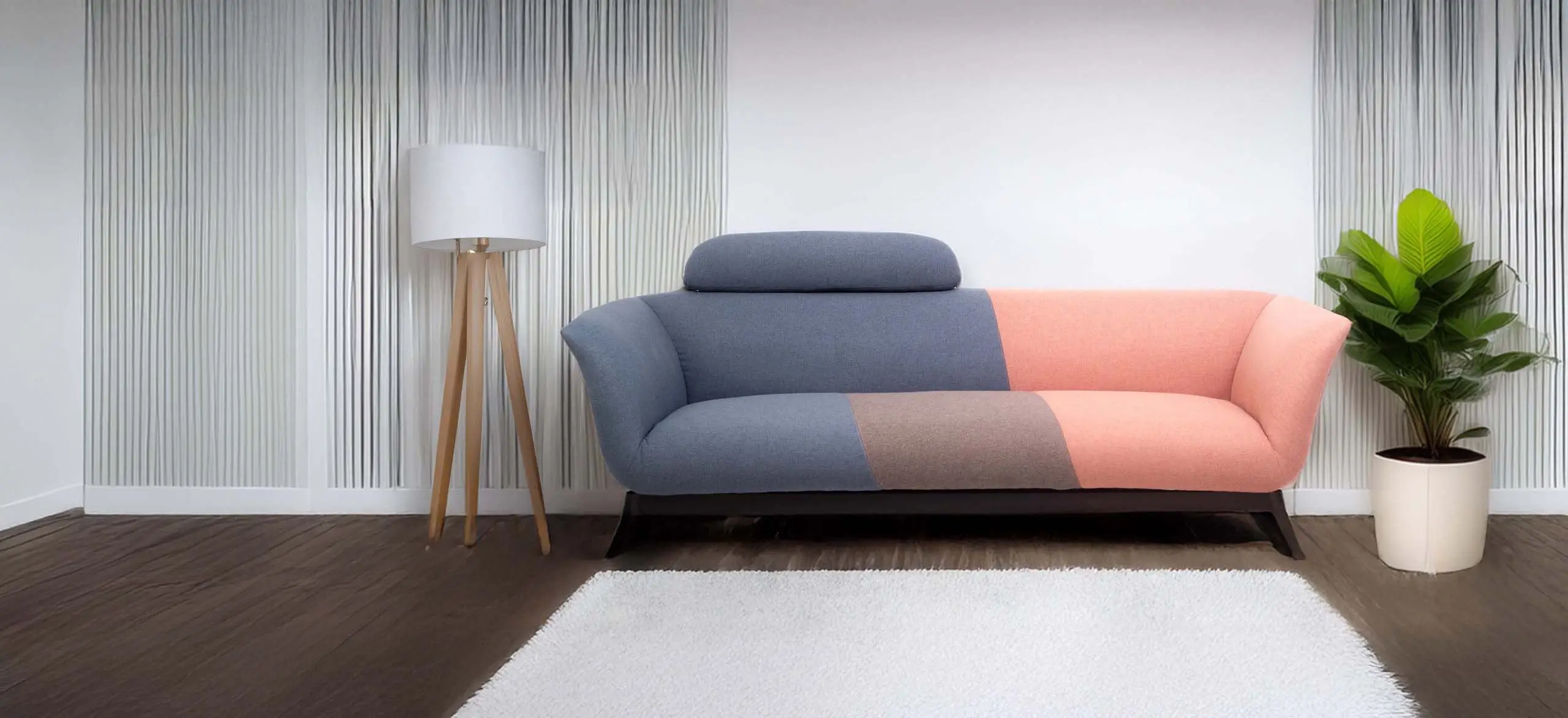 Modern office with a color-blocked sofa in blue, pink, and gray. A wooden lamp stands nearby, enhancing a cozy, productive atmosphere.