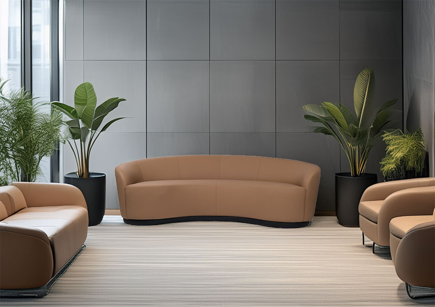 Modern waiting room with sleek tan sofas, large green potted plants, and a neutral-toned wall. The ambiance is calm and stylish.